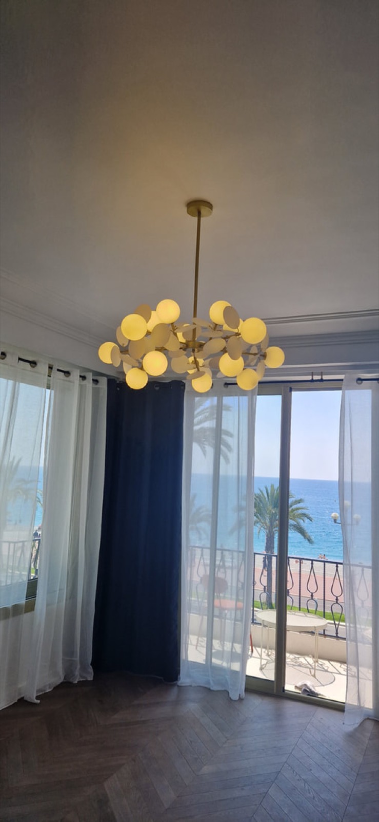 Lustre à globes dans un appartement avec vue sur la mer